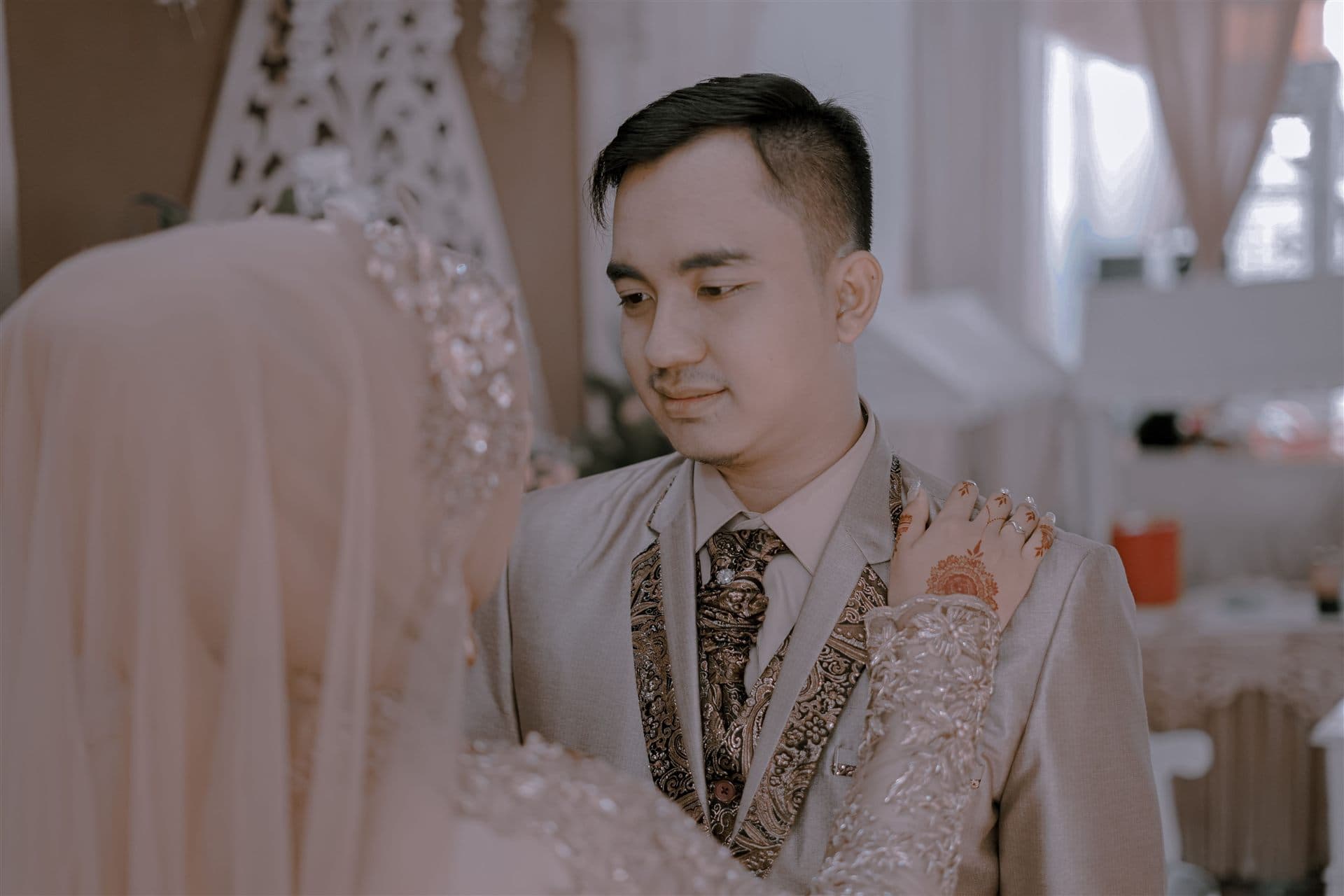 A couple at their nikah ceremony with an imam and their families