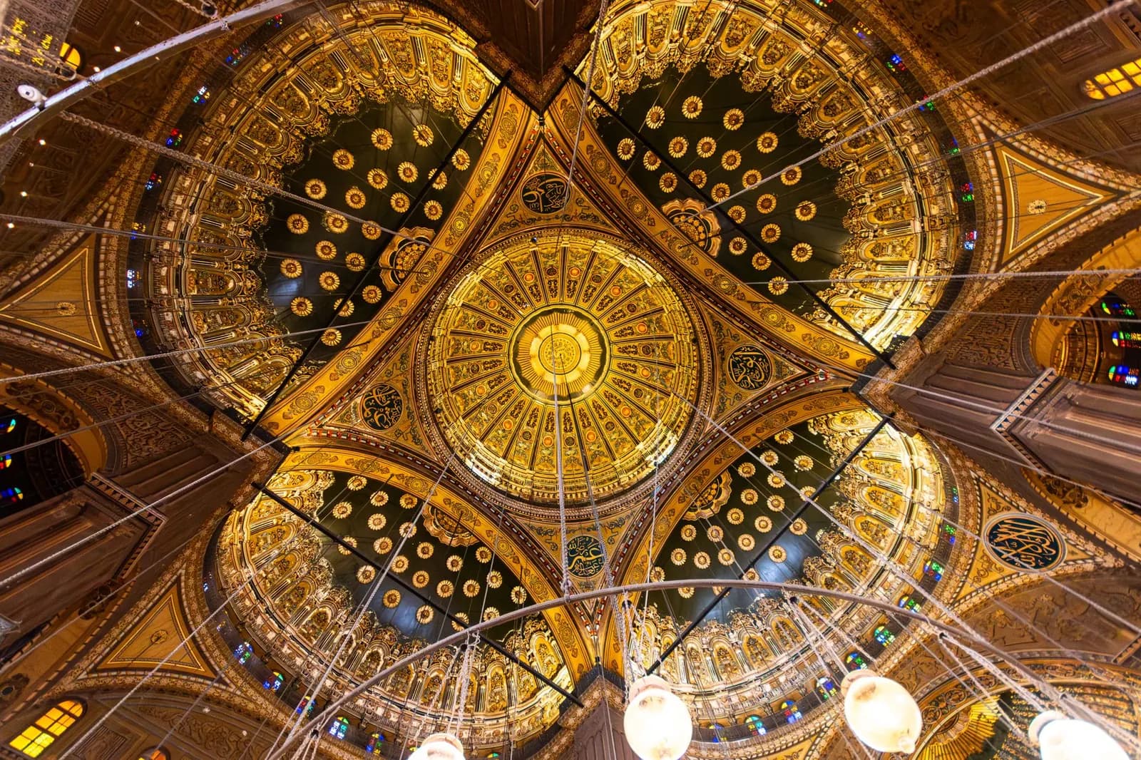 Golden domed ceiling of a historic mosque with intricate patterns and soft light.
