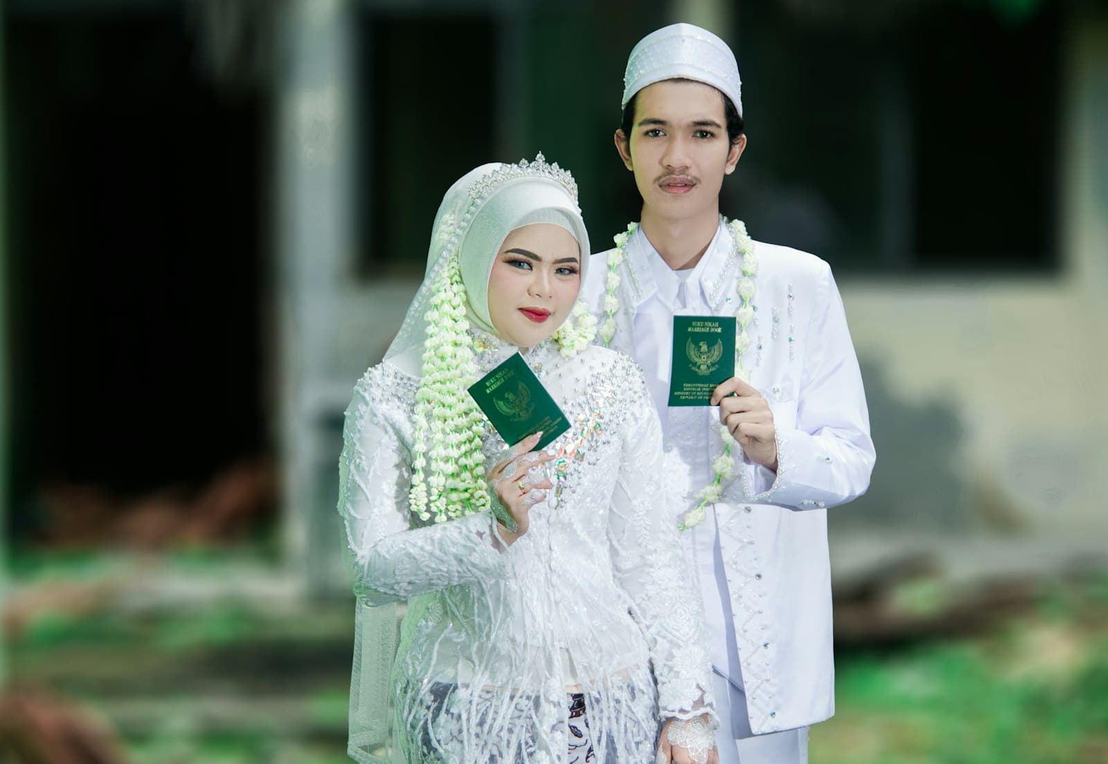A couple in white holding their marriage books